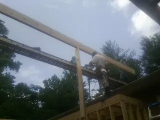 Carpenter setting a ridge beam over a new addition frame — Ice Dam Removal by Roofing Brothers in Sicklerville