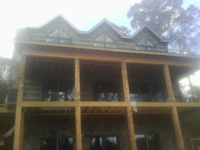 Dormers and porch framing on a large log home under construction — Roof Coating work by our crew in Sicklerville